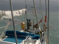 The solar panels (photovoltaic arrays) on this small yacht at sea can charge the 12 V batteries at up to 9 Amps in full, direct sunlight